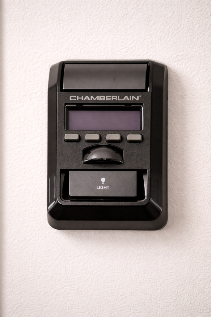 Chamberlain Garage Door Opener and Remote Setup: Complete Programming Guide 4 Chamberlain wall control panel mounted on a wall, featuring display screen and control buttons for managing a Chamberlain garage door opener system.