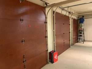 A brown wooden garage door installed in a residential house.